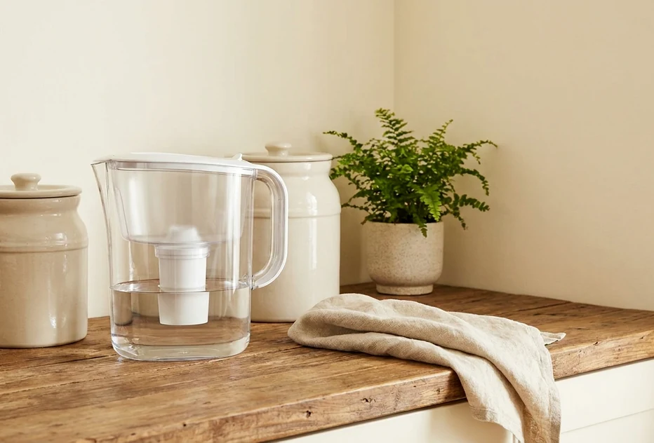 Neat wooden table with water pitcher and clean water containers